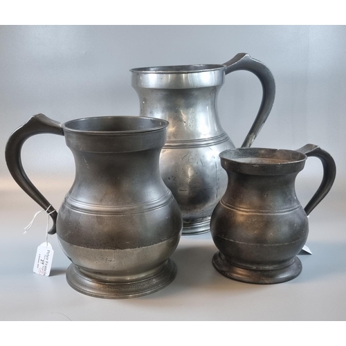 27 - Three 19th Century pewter pot bellied tankards. The largest 25cm high approx and marked 1 gallon. (3... 