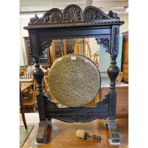 500 - Early 20th century ornately carved brass and oak dinner gong on stand with striker.  Height 105cm ap... 