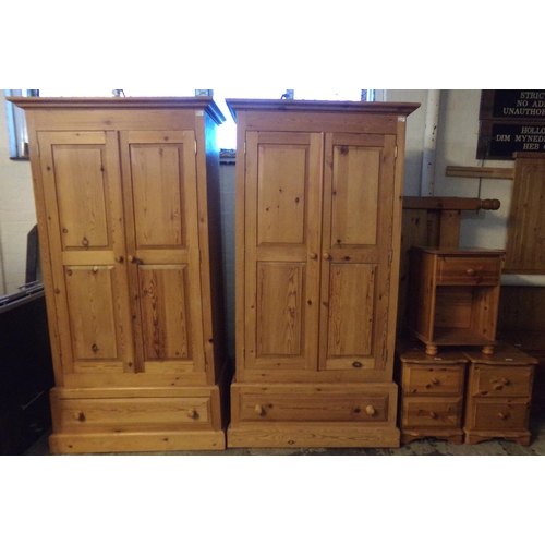 620 - Pair of natural pine two door blind panelled wardrobes, both with under drawers on platform bases.  ... 