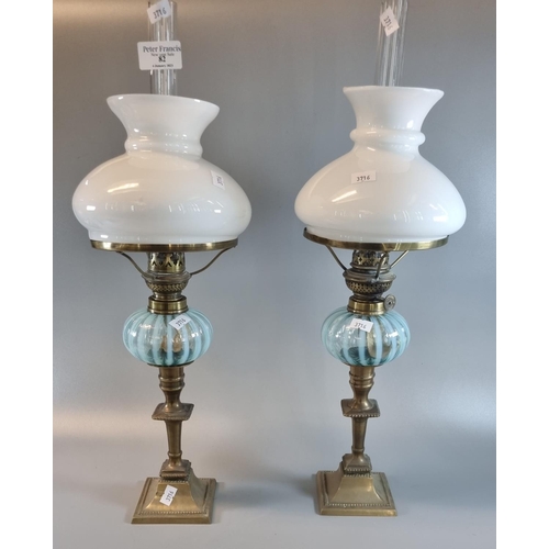 82 - Pair of vintage single oil burners, having opaline glass mushroom shades, above a blue and clear art... 