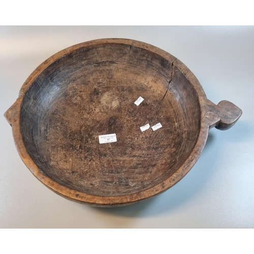 87 - Primitive design wooden bowl with shaped handle.  Diameter 40cm approx.   (B.P. 21% + VAT)