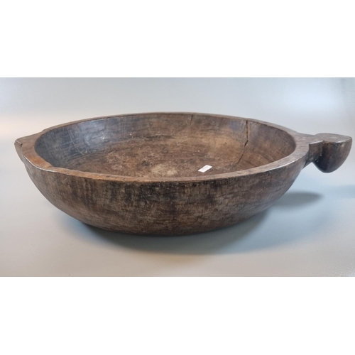 87 - Primitive design wooden bowl with shaped handle.  Diameter 40cm approx.   (B.P. 21% + VAT)