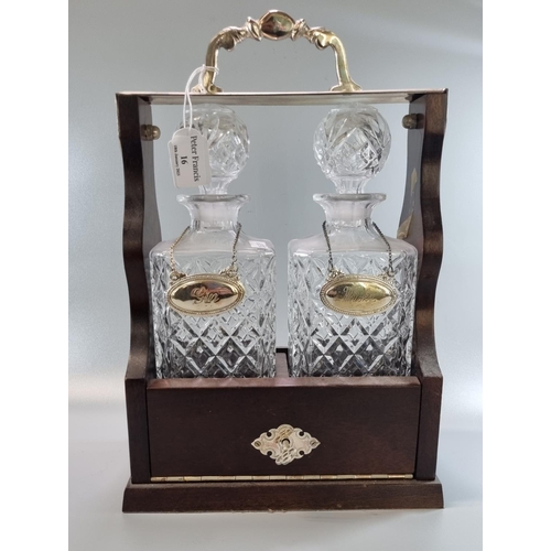 16 - Reproduction mahogany finish and glass two section tantalus with Gin and Whisky silver plated decant... 