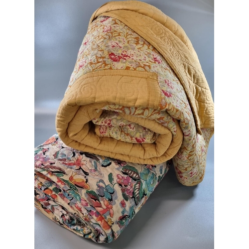 176 - Two vintage quilts; one with a floral print and the other a cotton patchwork on a mustard ground wit... 