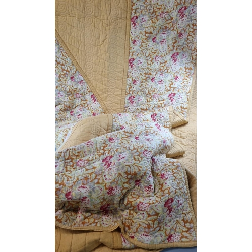 176 - Two vintage quilts; one with a floral print and the other a cotton patchwork on a mustard ground wit... 