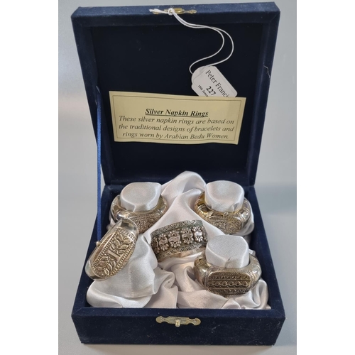 227 - Set of four silver napkin rings based on the traditional designs of bracelets and rings worn by Arab... 