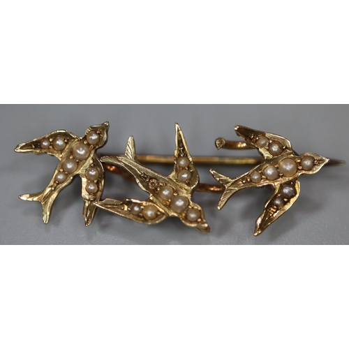 255 - A yellow metal triple swallow brooch set with seed pearls.
Approx weight 2.3 grams.
(B.P. 21% + VAT)