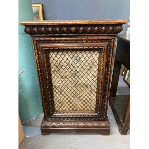 514 - Early 20th century ornately carved oak single door cabinet with mesh and fabric panel, the interior ... 