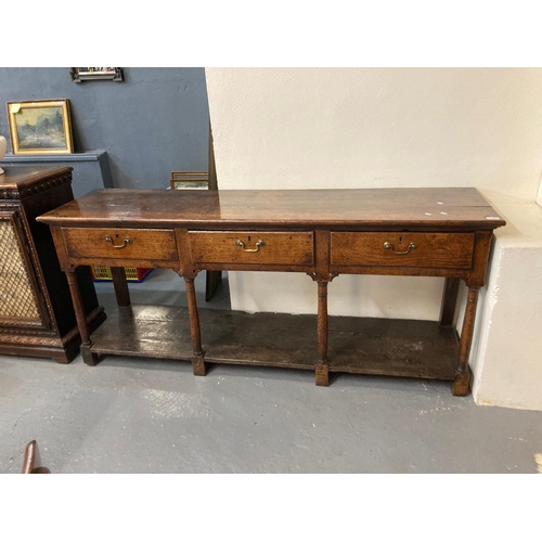 516 - Early 19th century Welsh oak dresser base, the moulded top above three drawers with brass swan neck ...
