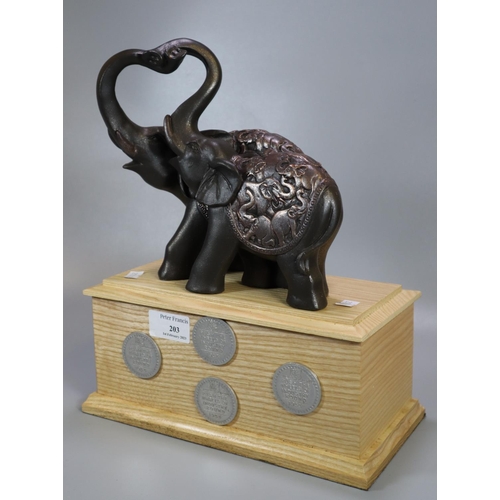 203 - Pair of composition amorous elephants on a wooden plinth with 'Push the wheels of Industry 1933' tok... 