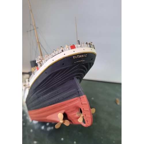 95 - Modern cased diorama of 'The sinking of the Titanic', the top with a painted porthole and the sides ... 