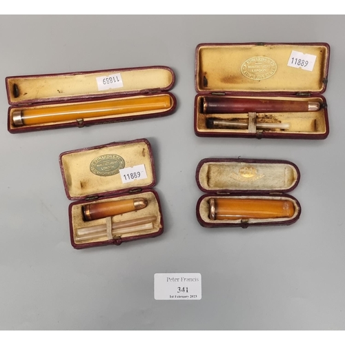 341 - Plastic tub containing four cased gold and amber cheroot holders.  (B.P. 21% + VAT)