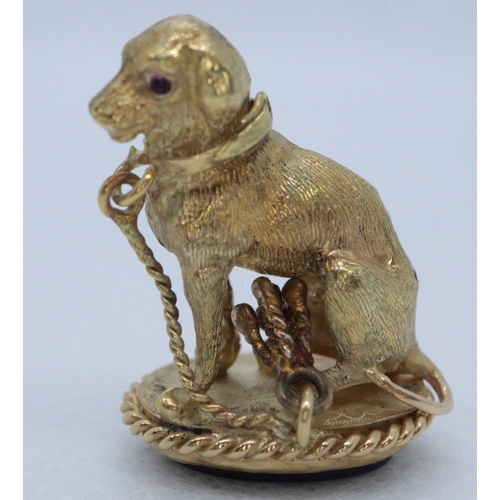 260 - Yellow metal hound or dog shaped charm with semi-precious stone set into base. 
(B.P. 21% + VAT)