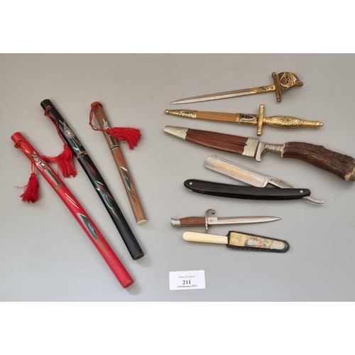 211 - Plastic tub of souvenir and other items, to include: miniature bayonets and daggers, cut throat razo... 