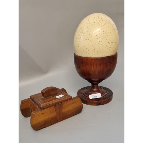 223 - Large Ostrich egg with treen goblet together with a wooden lidded box in the form of a stylised tank... 