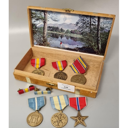 339 - Wooden cigar box containing assorted USA military medals: 1939-45 War Medal, Bronze Star, Defence Se... 