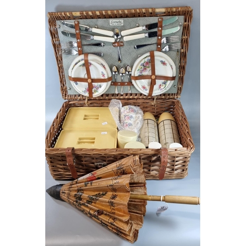 83 - Fully fitted cane/wicker picnic hamper.  Together with a Japanese parasol.  (2)  (B.P. 21% + VAT)