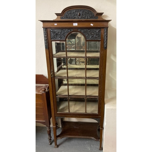 491 - Edwardian ornately carved mahogany single door glazed display cabinet with under tier on square tape... 