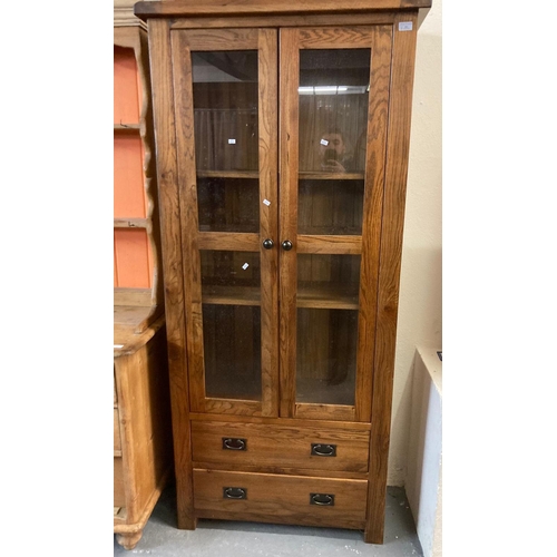 502 - Good quality modern oak two door glazed display cabinet, the two doors above an arrangement of two d... 