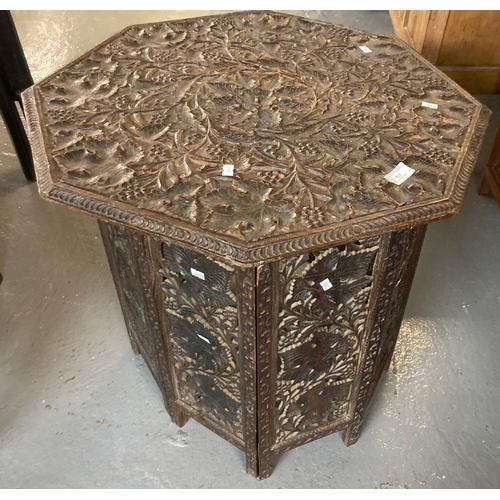 533 - Early 20th century ornately carved octagonal folding lamp table, carved overall with leaves and berr... 