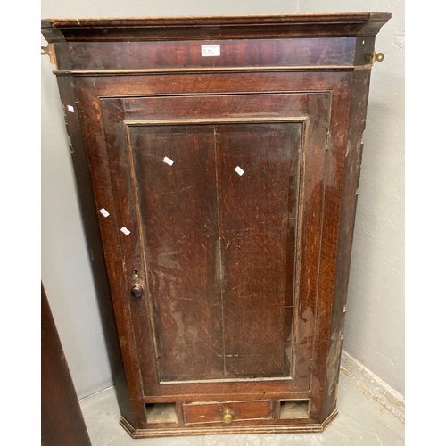 538 - Early 19th oak hanging corner cupboard with blind panelled door revealing shaped shelves to the inte... 