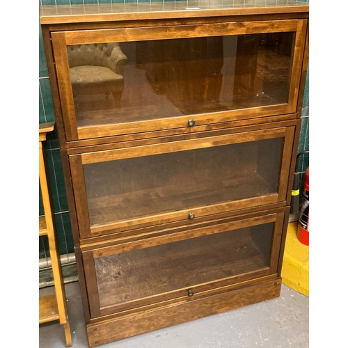 588 - Stained beech three section glazed bookcase with up-over doors.  79cm wide approx.  (B.P. 21% + VAT)