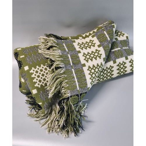 93A - Vintage woollen Welsh tapestry green ground blankets; one olive green with fringed edges in traditio... 