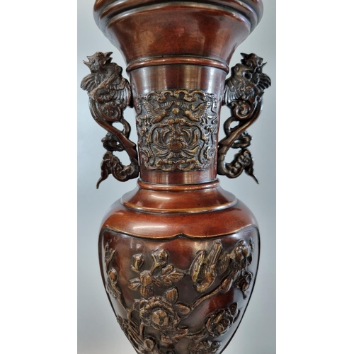 172 - Matching pair of Oriental bronze baluster vases on integral tripod stands with phoenix handles and m... 