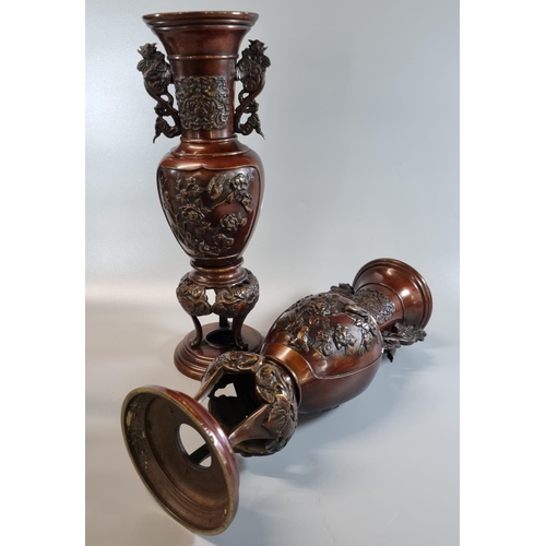 172 - Matching pair of Oriental bronze baluster vases on integral tripod stands with phoenix handles and m... 