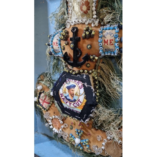 212 - Cased anchor shaped Sailor's Valentine, overall decorated with printed panels, studs, tassels and an... 