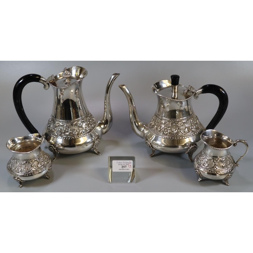 257 - Indian white metal four piece tea service comprising teapot and water jug with ebonised handles, cre... 