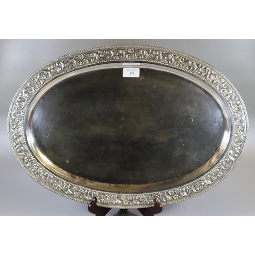 262 - Silver Indian shallow tray of oval form, overall decorated with flowerheads, scroll work and foliage... 