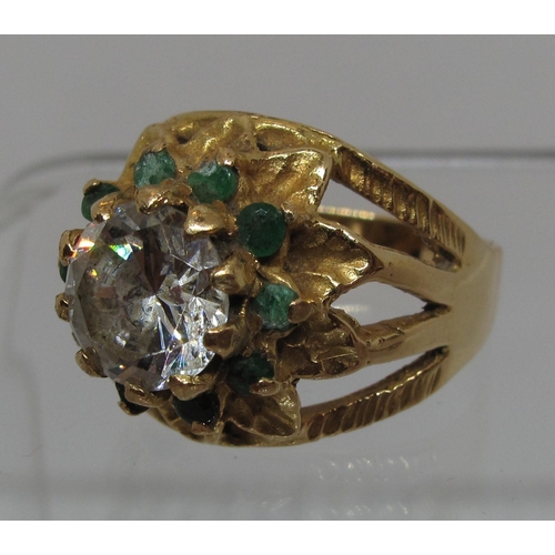 289 - 18ct gold flower ring set with a large white stone surrounded by emeralds.  Ring size O.  Approx wei... 