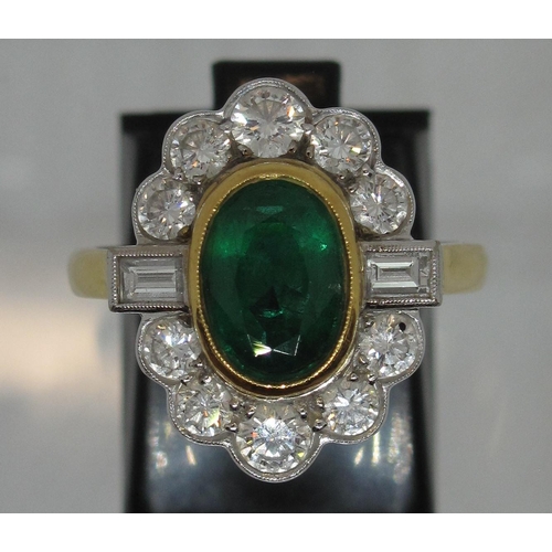 296 - A large emerald and diamond cluster ring.  The oval emerald approx 9x6mm surrounded by ten brilliant... 