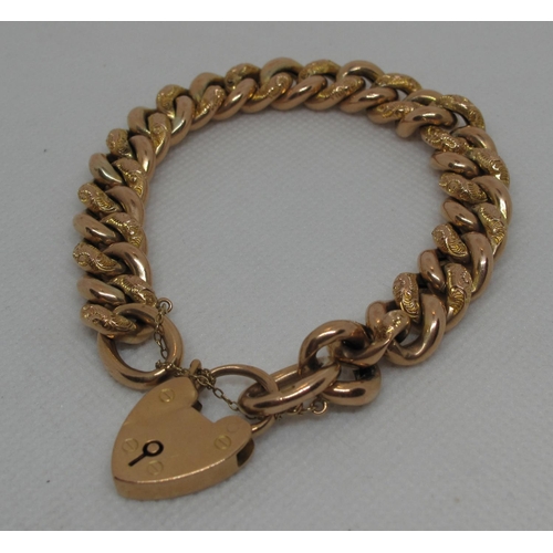 310 - 9ct gold curb link bracelet with engraved links and heart shaped clasp.  Approx weight 28.2 grams.
(... 