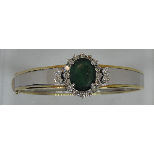 315 - Emerald and diamond hinged bangle set in yellow and white 18ct gold.  The treated emerald approx 14x... 