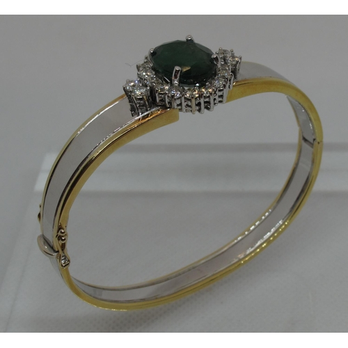 315 - Emerald and diamond hinged bangle set in yellow and white 18ct gold.  The treated emerald approx 14x... 