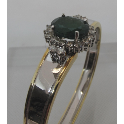 315 - Emerald and diamond hinged bangle set in yellow and white 18ct gold.  The treated emerald approx 14x... 