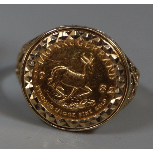 410 - 1/10 Krugerrand gold coin dated 1982 in a 9ct gold foliate and pierced ring mount. 6.1g approx. 
(B.... 