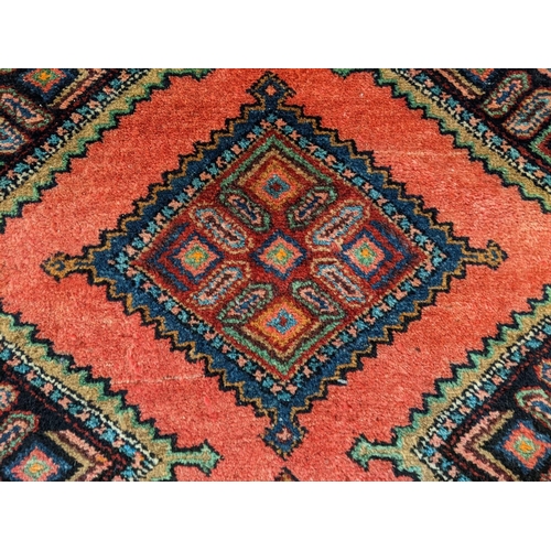 426 - Washed red ground Persian Meshkin runner with diamond medallion geometric design.  274x92cm approx. ... 