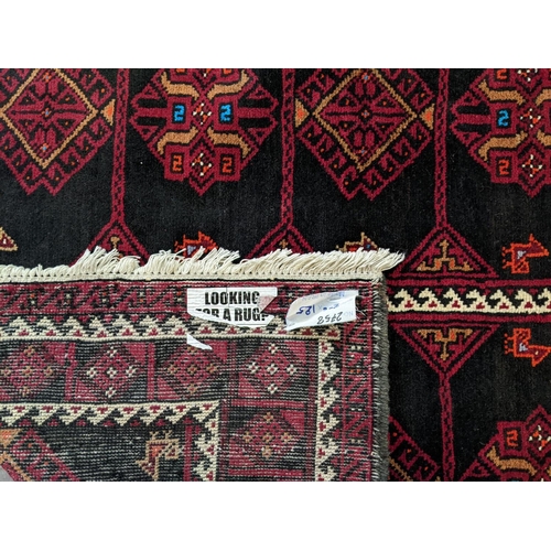 427 - Full pile deep ground red Persian Beluch tribal rug with diamond and geometric medallions.  206x125c... 