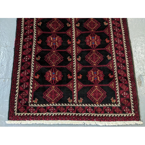 427 - Full pile deep ground red Persian Beluch tribal rug with diamond and geometric medallions.  206x125c... 