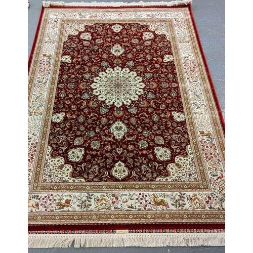 428 - Fine woven bamboo silk red ground rug with central foliate medallion and animal motifs including sty... 