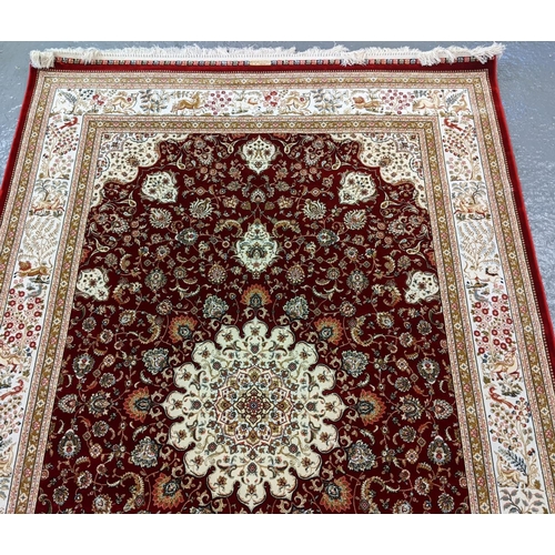 428 - Fine woven bamboo silk red ground rug with central foliate medallion and animal motifs including sty... 