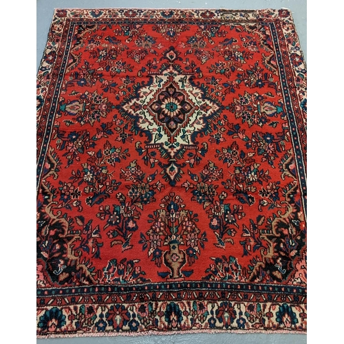 435 - Red ground Persian Saruk village carpet overall with central floral medallion and decorated with mul... 