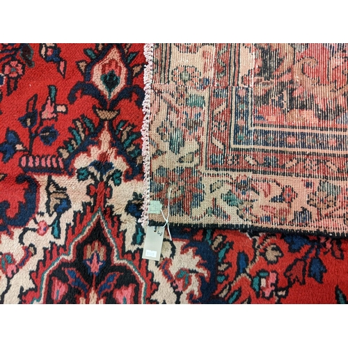 435 - Red ground Persian Saruk village carpet overall with central floral medallion and decorated with mul... 