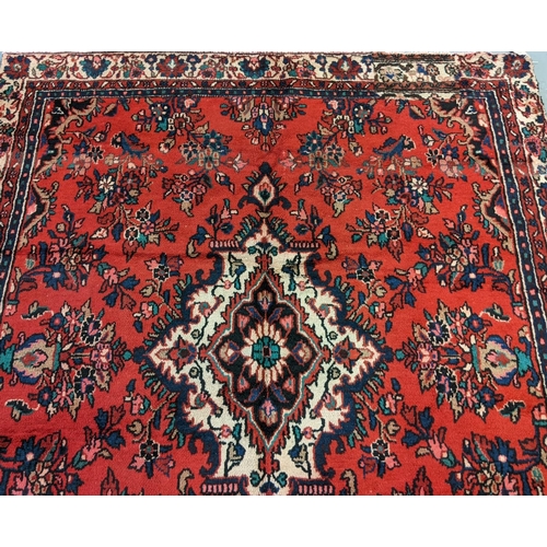 435 - Red ground Persian Saruk village carpet overall with central floral medallion and decorated with mul... 