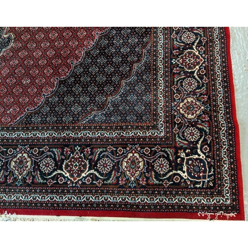 437 - Rich red ground full pile Iranian carpet of Persian Kashan design.   (B.P. 21% + VAT)