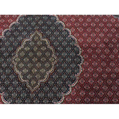 437 - Rich red ground full pile Iranian carpet of Persian Kashan design.   (B.P. 21% + VAT)