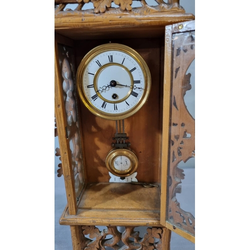 71 - German Black Forest design foliate decorated mantle clock, having white Roman face and exposed pendu... 